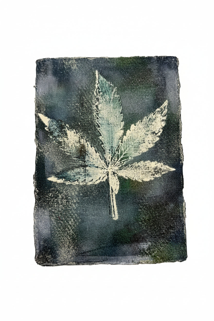 A square dark charcoal or black ink print featuring a light-colored leaf design, displayed against a plain off-white background.